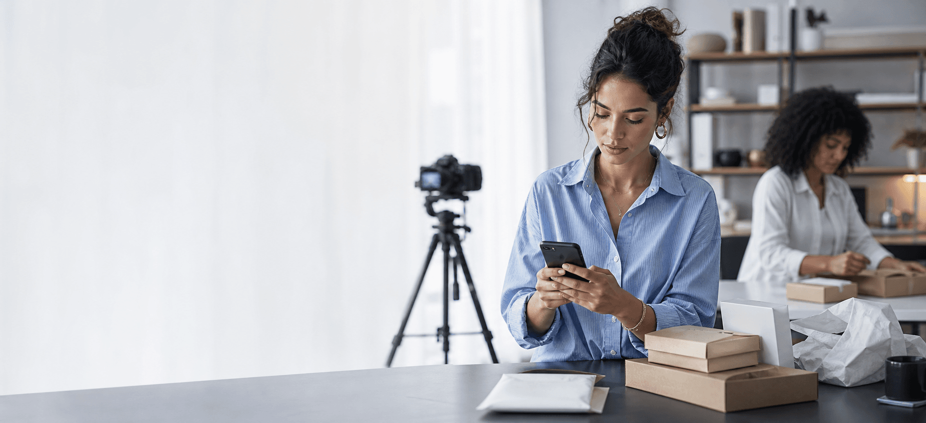 A creator and assistant coordinating customer conversations and product orders in a content studio